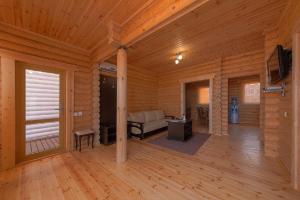 a living room of a log cabin with a couch and a television at Hotel White beach All Inclusive in Anapa