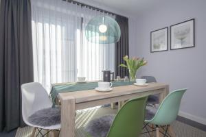 een eetkamer met een houten tafel en groene stoelen bij Südstrandquartier - Ferienwohnung Cor in Ostseebad Sellin