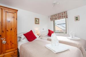 two beds in a bedroom with red and white pillows at 22 John Walker House in York