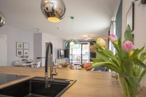 uma cozinha com um lavatório e um vaso de flores em Südstrandquartier - Ferienwohnung Loft em Ostseebad Sellin