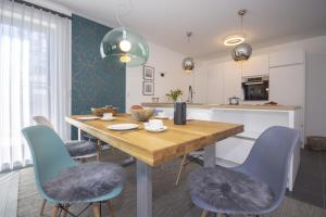 uma cozinha e sala de jantar com uma mesa de madeira e cadeiras em Südstrandquartier - Ferienwohnung Loft em Ostseebad Sellin