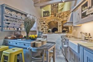 a kitchen with blue cabinets and a table with yellow stools at Casa Metropolis in Apérion
