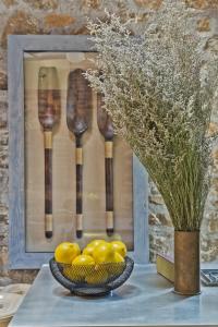 a bowl of lemons and a vase of flowers and spoons at Casa Metropolis in Apérion