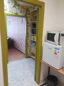 a kitchen with a microwave and a refrigerator at Apartament Erfolg 11 in Daugavpils