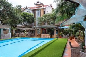 a swimming pool in front of a house at Comfort Gardens in Nairobi