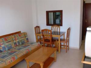 a living room with a couch and a table and chairs at Apartamentos Gemelos IV - Fincas Arena in Benidorm