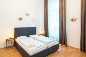 a hotel room with a bed and two lamps at Hybernska Apartments in Prague