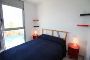 エンプリアブラバにあるApart-rent Apartment Puig Rom 0149のベッドルーム(青いベッド1台、大きな窓付)
