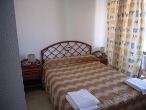 ベニドルムにあるEl Marino - Fincas Arenaのベッドルーム1室(ベッド1台付)、タオル付きの2泊スタンド