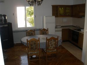 une cuisine avec une table et des chaises ainsi qu'une fenêtre dans l'établissement Apartments Sunce, à Mlini