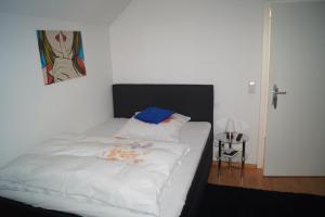 - une chambre dotée d'un lit blanc avec une photo sur le mur dans l'établissement Residenz Labee, à Weil am Rhein