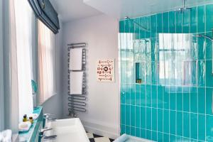 a bathroom with a green tiled shower and a sink at ABode Manchester in Manchester +37 photos