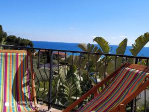 een balkon met een stoel en uitzicht op de oceaan bij mansarda mare bella vista CITRA zero zero ottanta trentuno LT O738 in Imperia