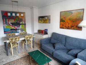 a living room with a blue couch and a table at LA GALERÍA in Avila