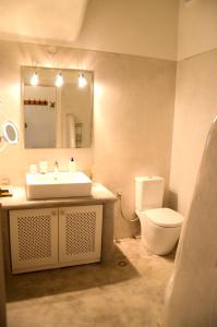 a bathroom with a sink and a toilet and a mirror at Hillside Kolona View Villa in Mérikhas