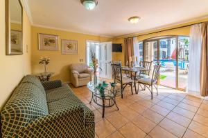 Aparthotel Serena Dream في لا سيرينا: غرفة معيشة مع أريكة وطاولة