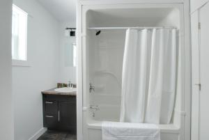 baño con ducha con cortina blanca en Appalachian Chalets & RV, en Corner Brook