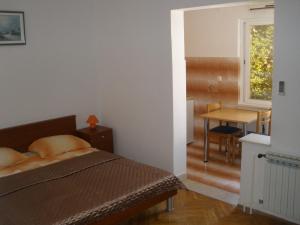 a bedroom with a bed and a table and a window at Apartments Sunce in Mlini