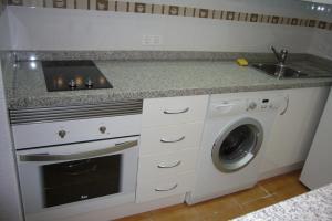 a kitchen with a sink and a washing machine at Las Palmeras III- Fincas Arena in Benidorm
