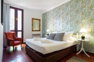 1 dormitorio con 1 cama grande y pared de flores en Dúplex en el centro de la ciudad, en Las Palmas de Gran Canaria