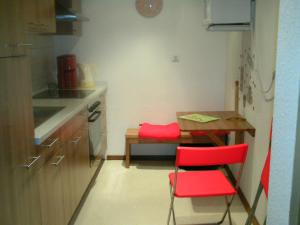 una piccola cucina con sedia rossa e tavolo di Riggers Hof a Wietzendorf