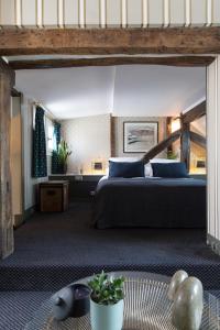 a bedroom with a large bed with blue pillows at Hôtel Le Relais Saint-Germain in Paris