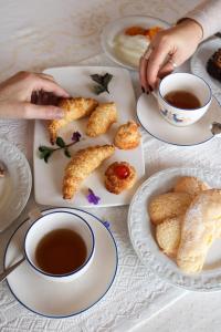 - une table avec des assiettes de nourriture et une tasse de thé dans l'établissement La Rosa dei Venti, à Sennariolo