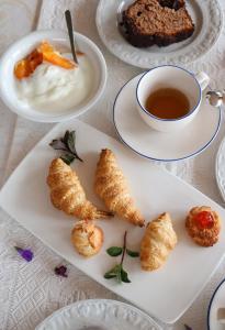 a white plate with pastries and a cup of tea at La Rosa dei Venti in Sennariolo