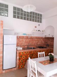 una cucina con frigorifero bianco e tavolo di Casa Martina a Peschici