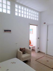 Camera bianca con sedia e finestra di Casa Martina a Peschici