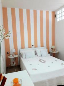 ein Schlafzimmer mit einem Bett und einer gestreiften Wand in der Unterkunft Casa Martina in Peschici