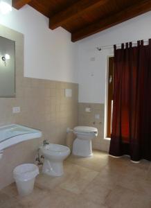 a bathroom with two toilets and a tub and a sink at Ape Rossa in Castellana Grotte