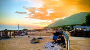 a beach with umbrellas and people on the sand at Glamping Rooms at The Sea Turtle in Dhërmi