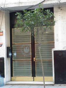 a tree in front of a building with a door at Excelente departamento en Retiro in Buenos Aires