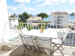 a patio with a white table and chairs on a balcony at Les pieds dans l'eau : grand T2 avec garage in La Ciotat