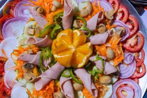 a plate of food with vegetables on a table at Comfort Gardens Sweetwaters in Nanyuki