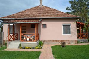 een klein huis met een veranda en een grasveld bij Liliom Apartman in Gyula