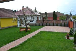 un parc avec un banc dans une cour dans l'établissement Liliom Apartman, à Gyula