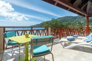 a table and chairs on a balcony with a view of the ocean at Coral Strand Smart Choice in Beau Vallon