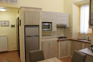 a kitchen with a refrigerator and a microwave at Casa La Marinella in Porto Santo Stefano