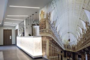 una gran biblioteca con un reloj en la pared en Mafra Hotel, en Mafra