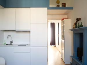 a kitchen with white cabinets and a fireplace at Silenzioso nido su 2 piani nella Milano più bella in Milan