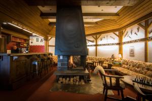 a restaurant with a fireplace in the middle of a room at Hotel La Collina in Saas-Fee