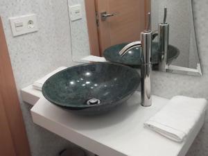 La salle de bains est pourvue d'un lavabo à bol vert sur un comptoir. dans l'établissement Casa Rural El Torreón II, à Caleruega