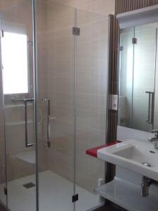 a bathroom with a glass shower and a sink at Casa Rural El Torreón II in Caleruega