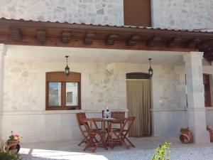 patio con tavolo e sedie sotto un portico di Casa Rural El Torreón II a Caleruega