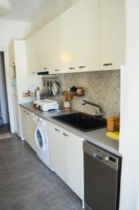 a kitchen with a sink and a washing machine at Hillside Kolona View Villa in Mérikhas