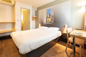 Changé的住宿－B&B HOTEL Laval Changé，酒店客房设有一张大床和一张书桌。
