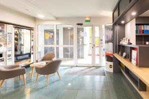 a living room with two chairs and a table at B&B HOTEL Laval Chang&eacute; in Chang&eacute;