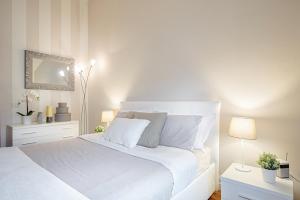 una camera bianca con letto bianco e specchio di J-HOME a Lucca